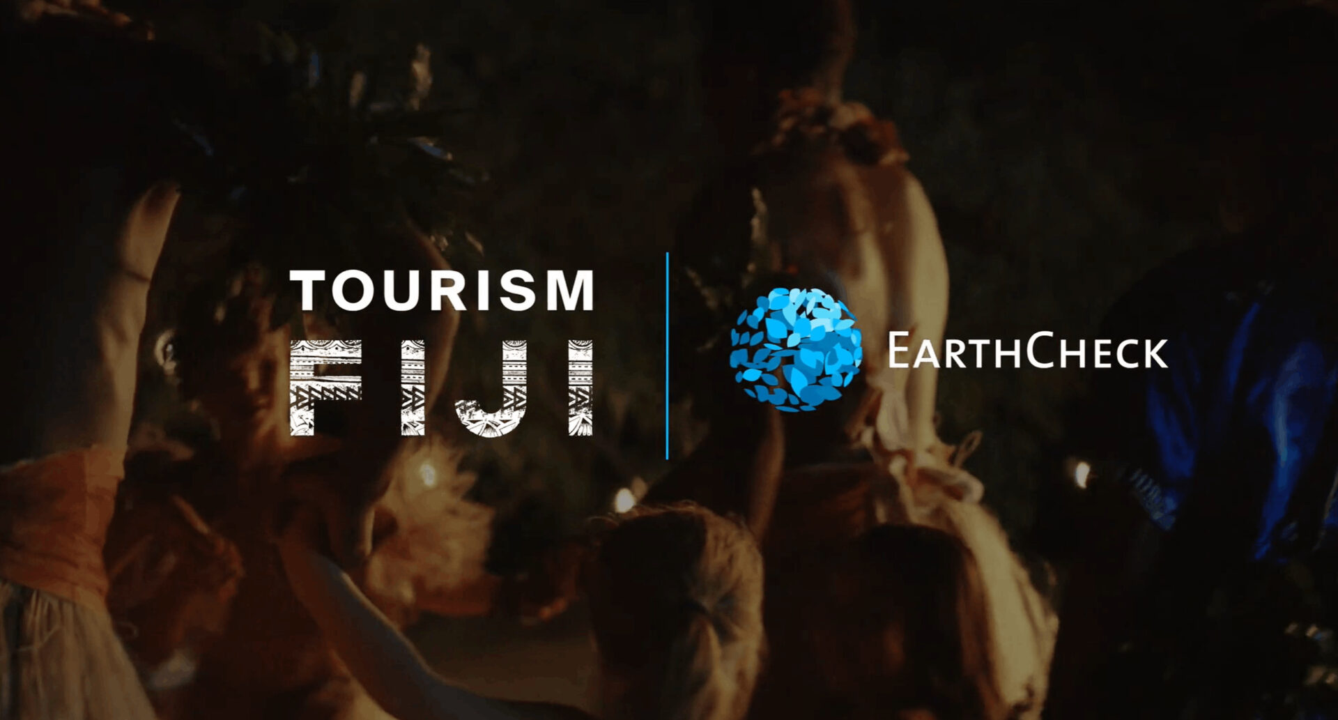 Tourism Fiji and EarthCheck logo overlayed over an image of people dancing in Fiji.