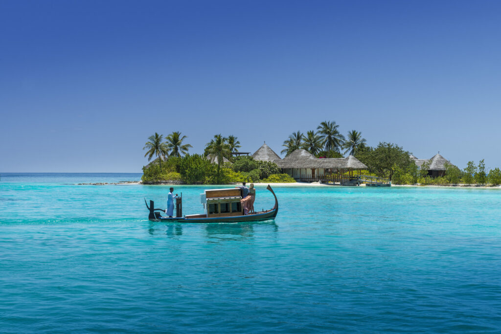 A boat in the water in front of an island at Maldives