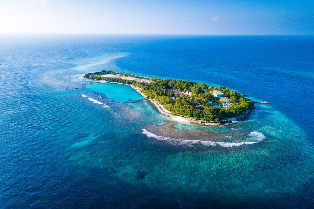 Aerial image of a small island in the Maldives, surrounded by ocean