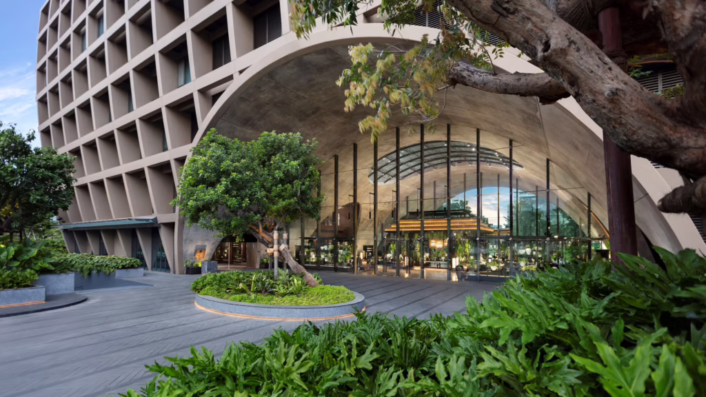 Hotel exterior with curved archway and green gardens