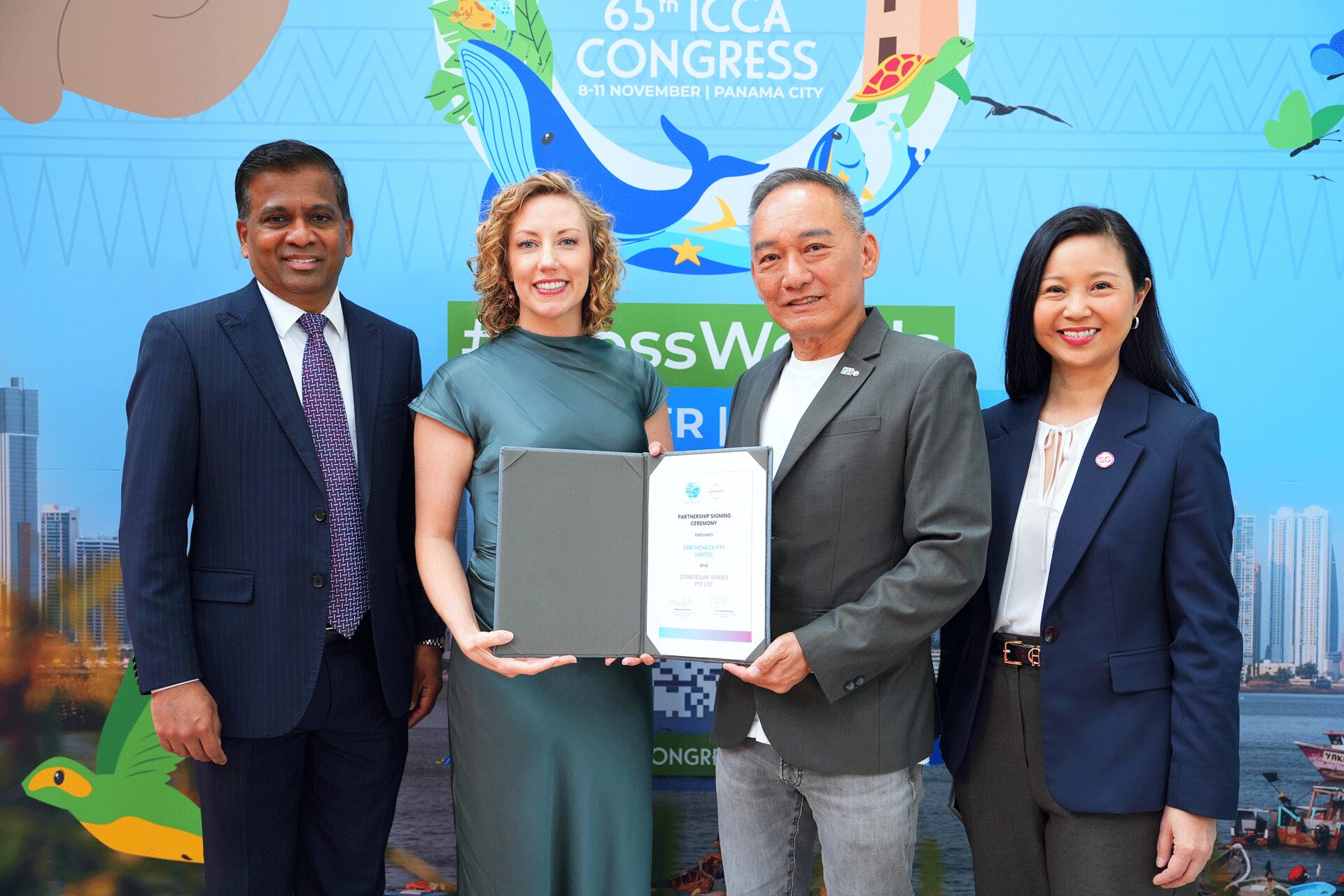 Group of four people holding a certificate in front of a congress backdrop