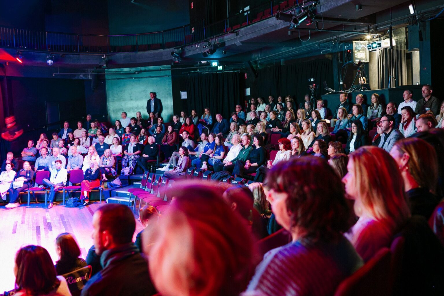 Event attendees in amphitheatre seating facing a stage