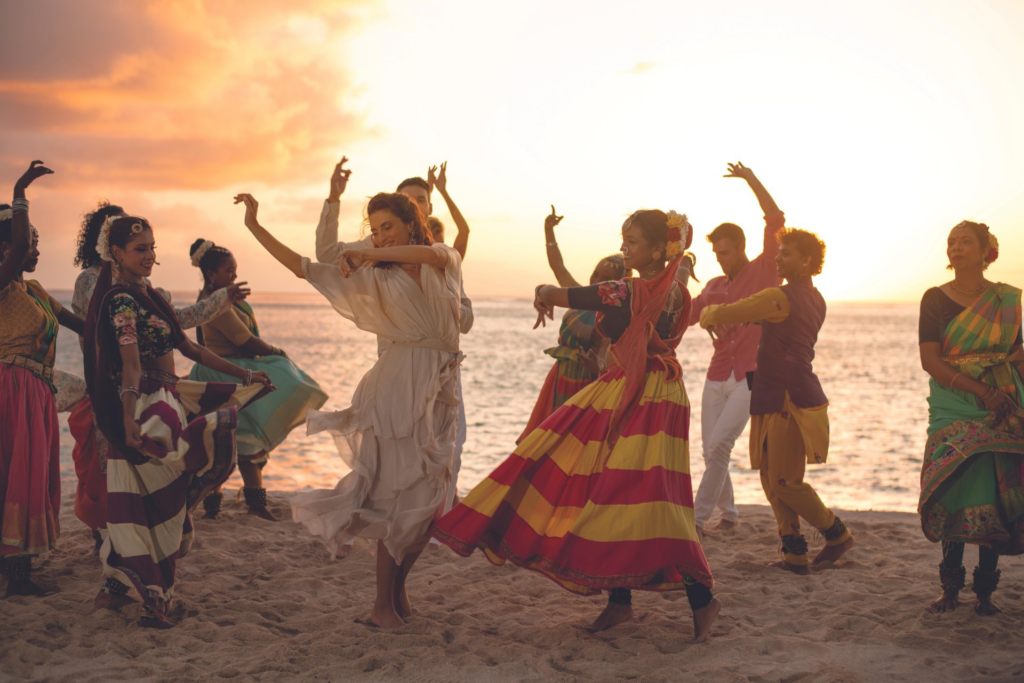 Group of people dancing at sunset on a beach